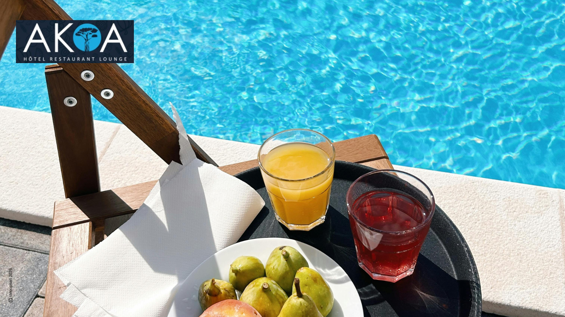 Plateau de fruits frais et jus de fruits au bord de la piscine de l'hôtel restaurant AKOA à Antananarivo.